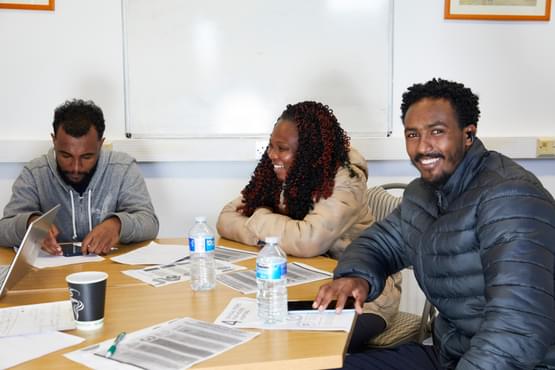 Three people sitting around a table with papers