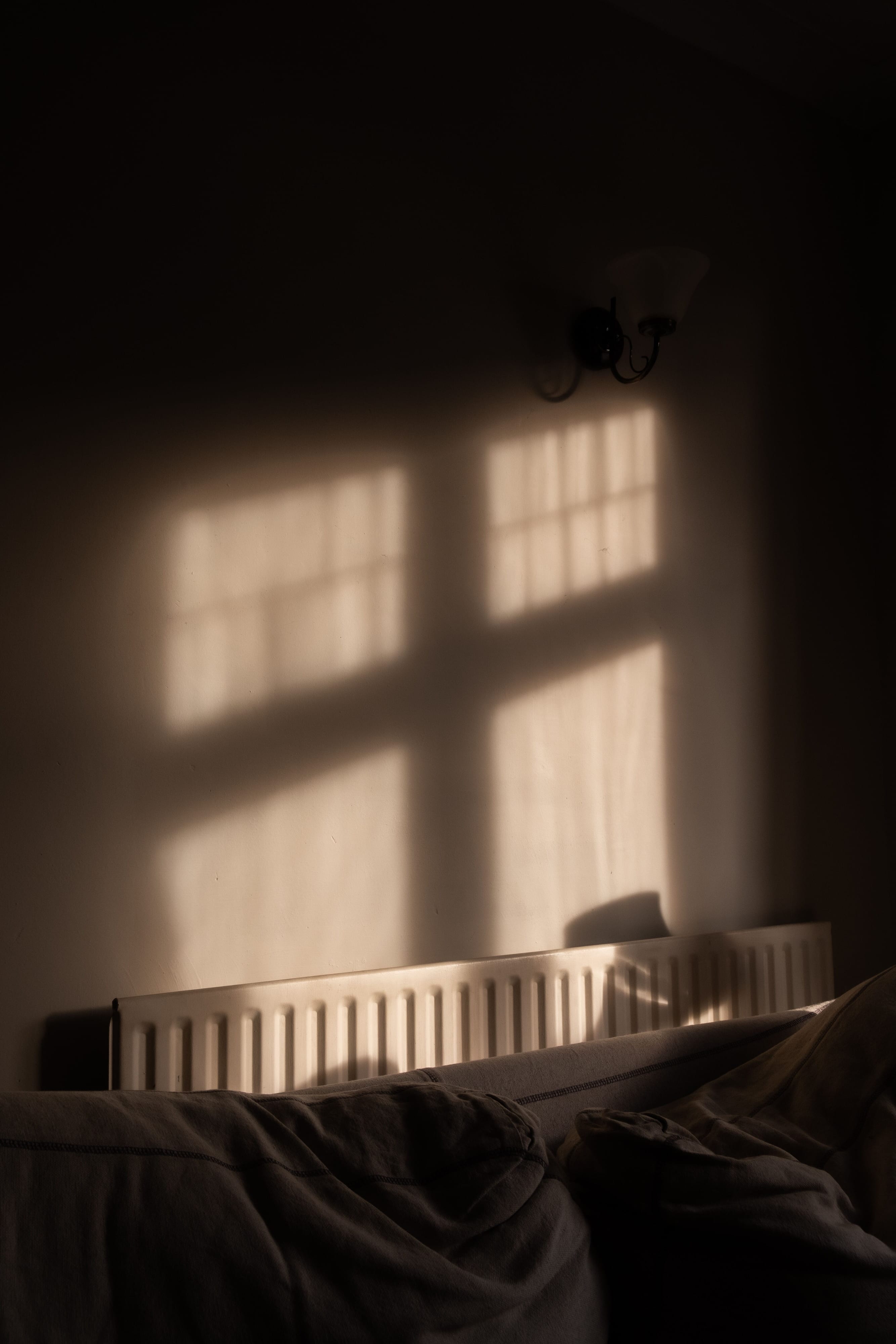 A radiator with a window's silhouette cast above it