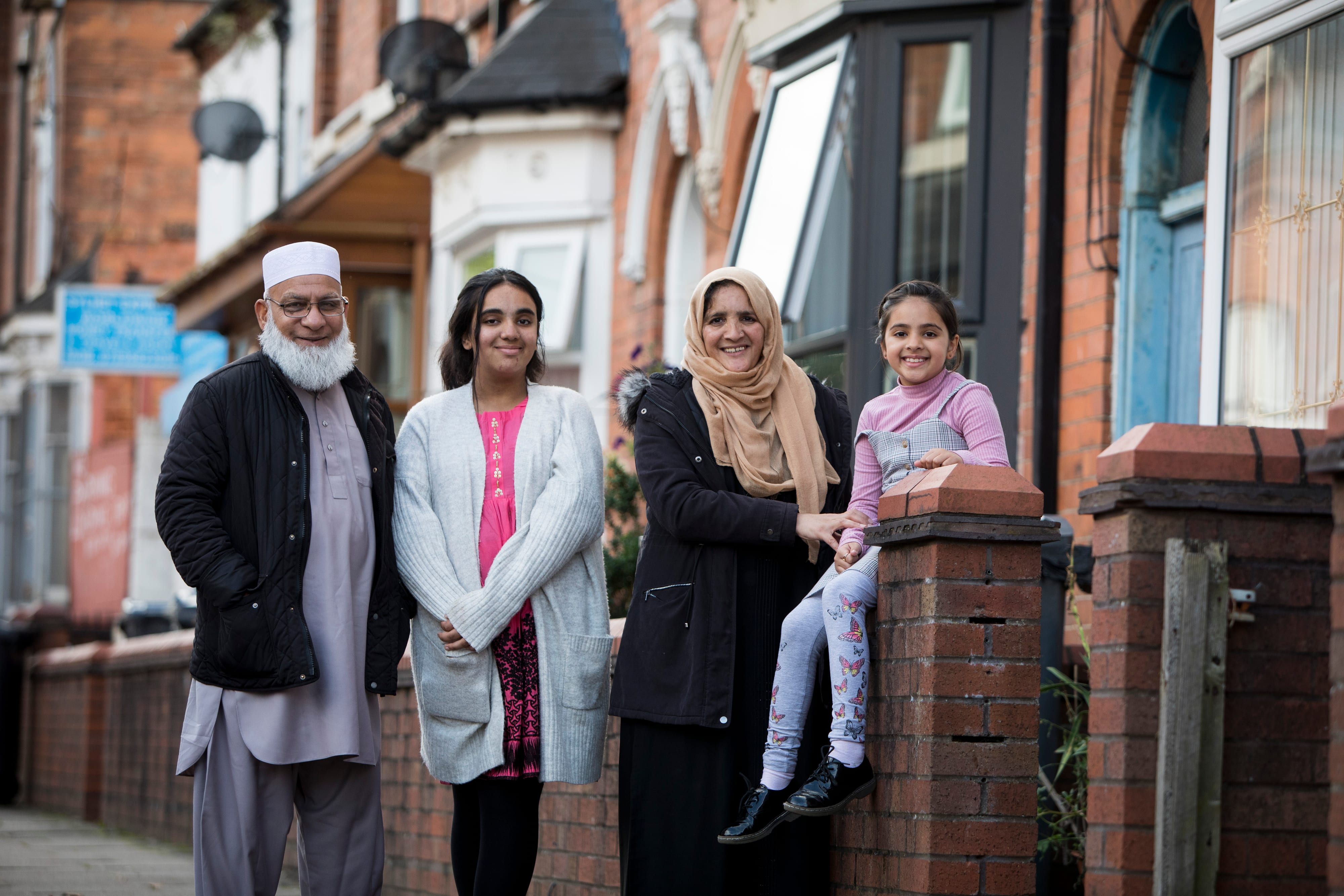 A family outside their house smiling