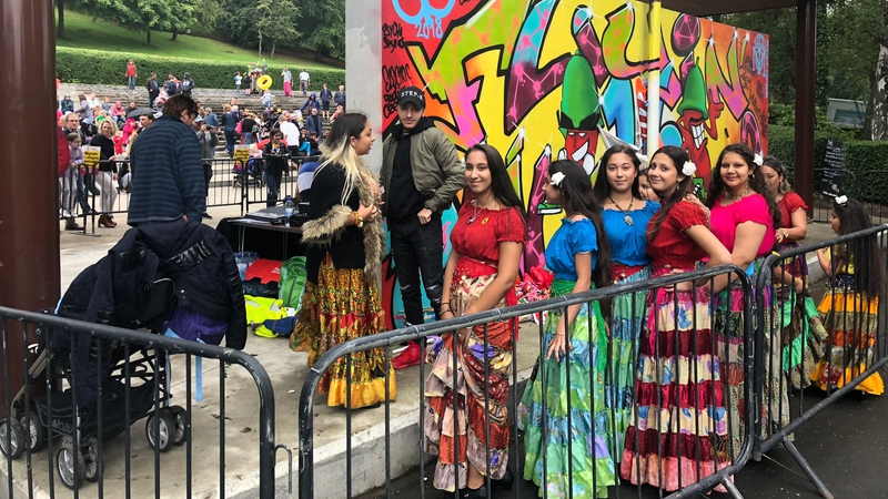 picture for projectStory: Women from the |Roma Community in Glasgow queueing for an outdoor gig at the Queen's Park bandstand in Govanhill. Behind them is a wall of colourful graffiti. picture for projectStory: Women from the |Roma Community in Glasgow queueing for an outdoor gig at the Queen's Park bandstand in Govanhill. Behind them is a wall of colourful graffiti.