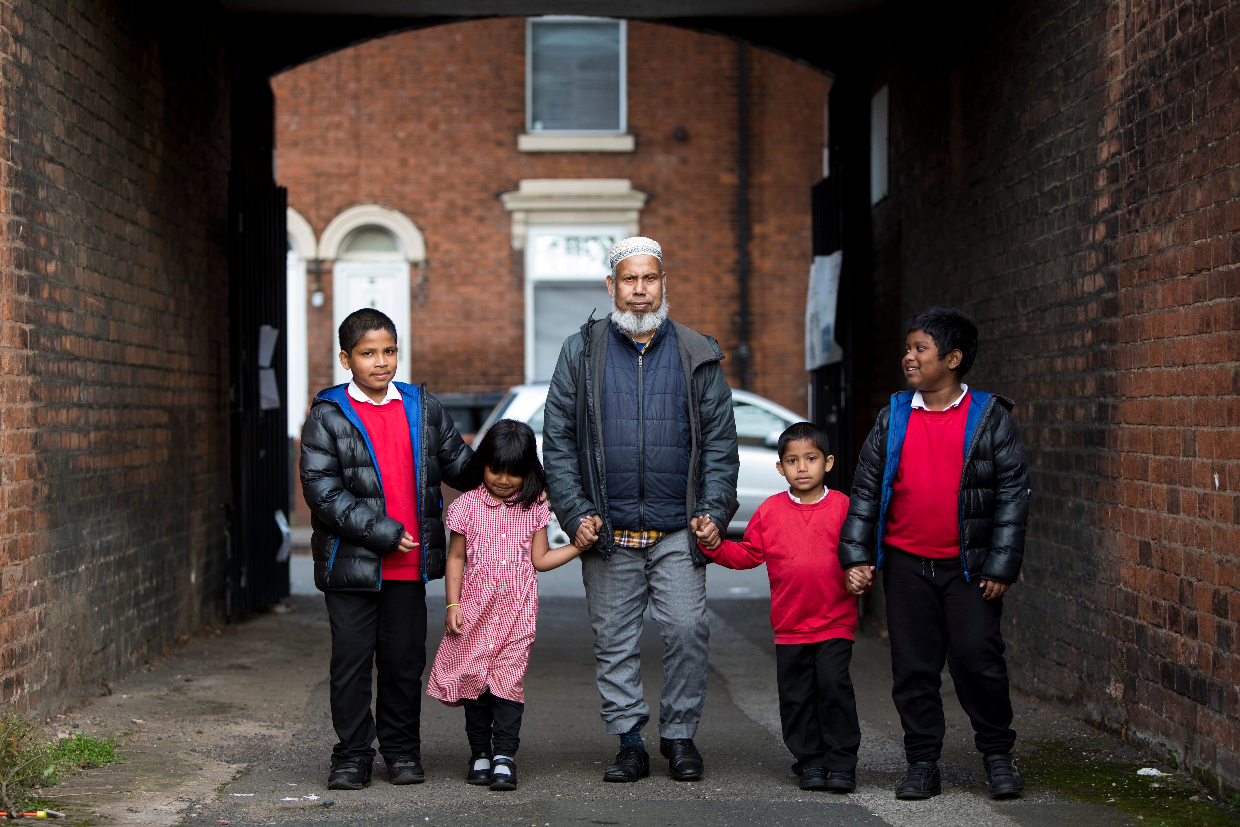 A Lozells family stands holding hands in a tunnel