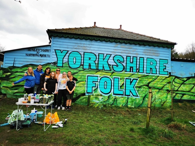 picture for projectStory: Young people stand in front of a building with graffiti reading Yorkshire Folk