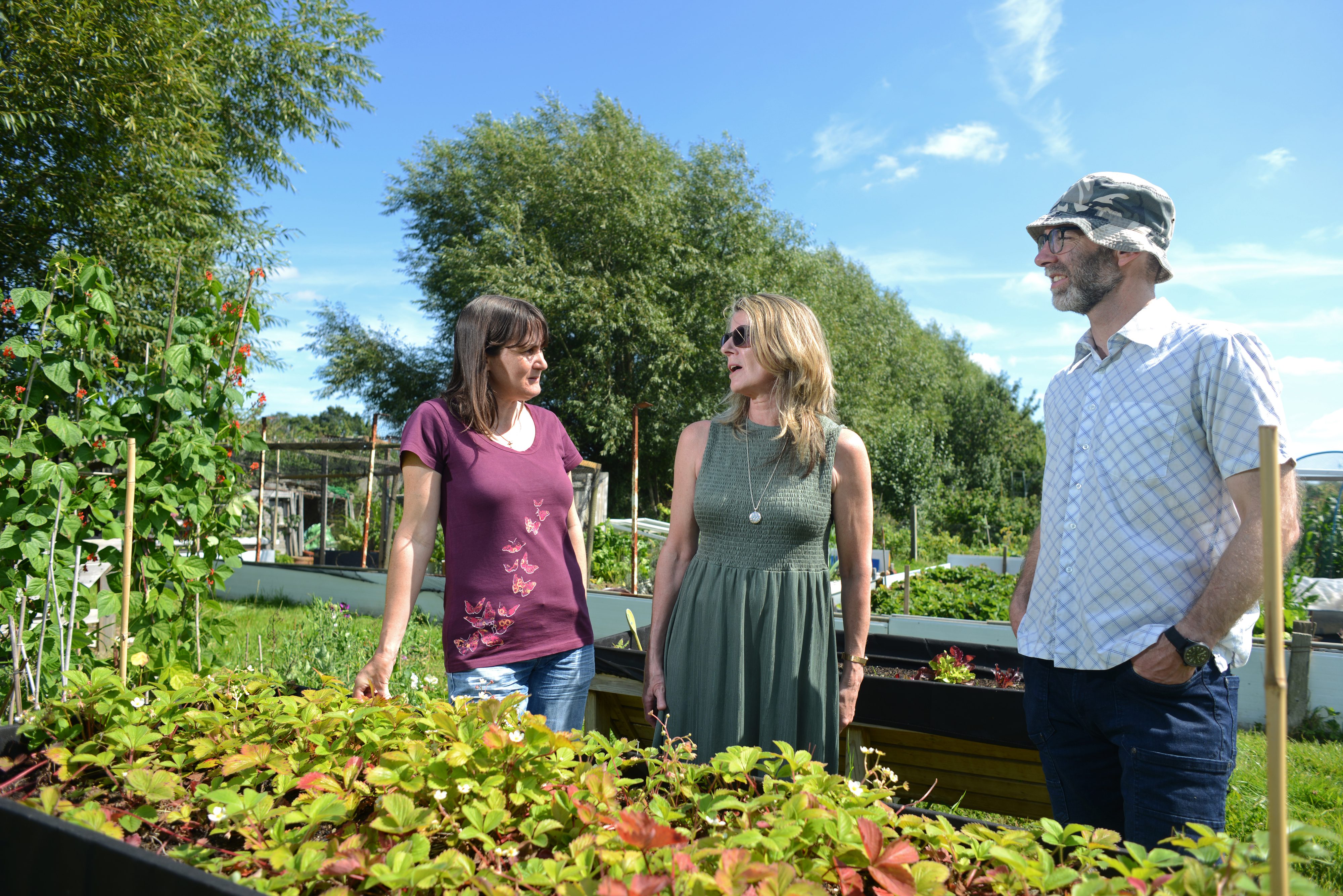 Three people talking in a garden