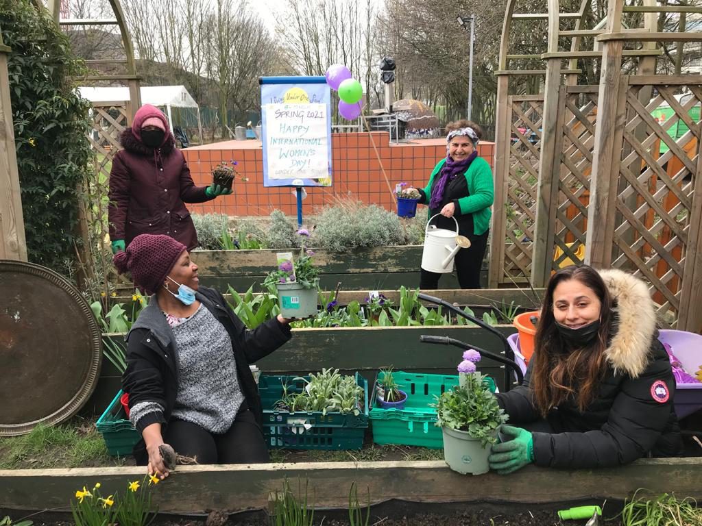 Participants plant flowers as part of Welcome Women project