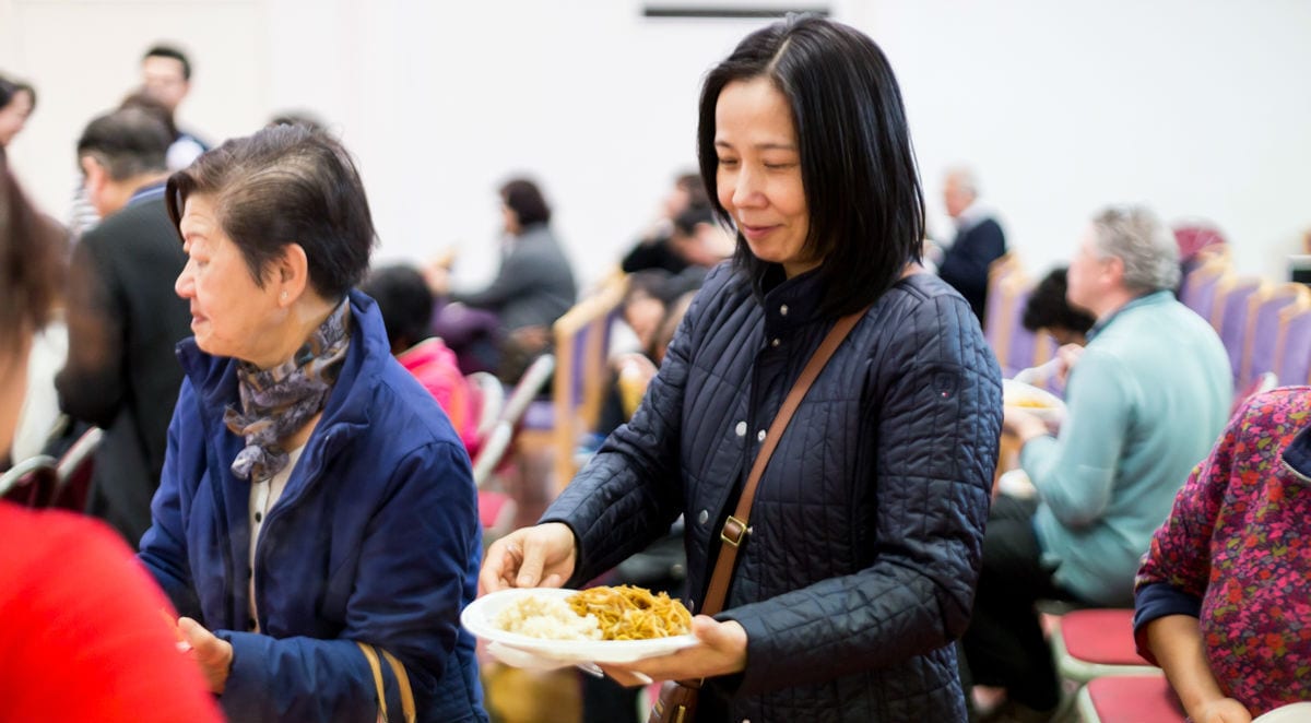 Woman being served food at Newham Chinese Association