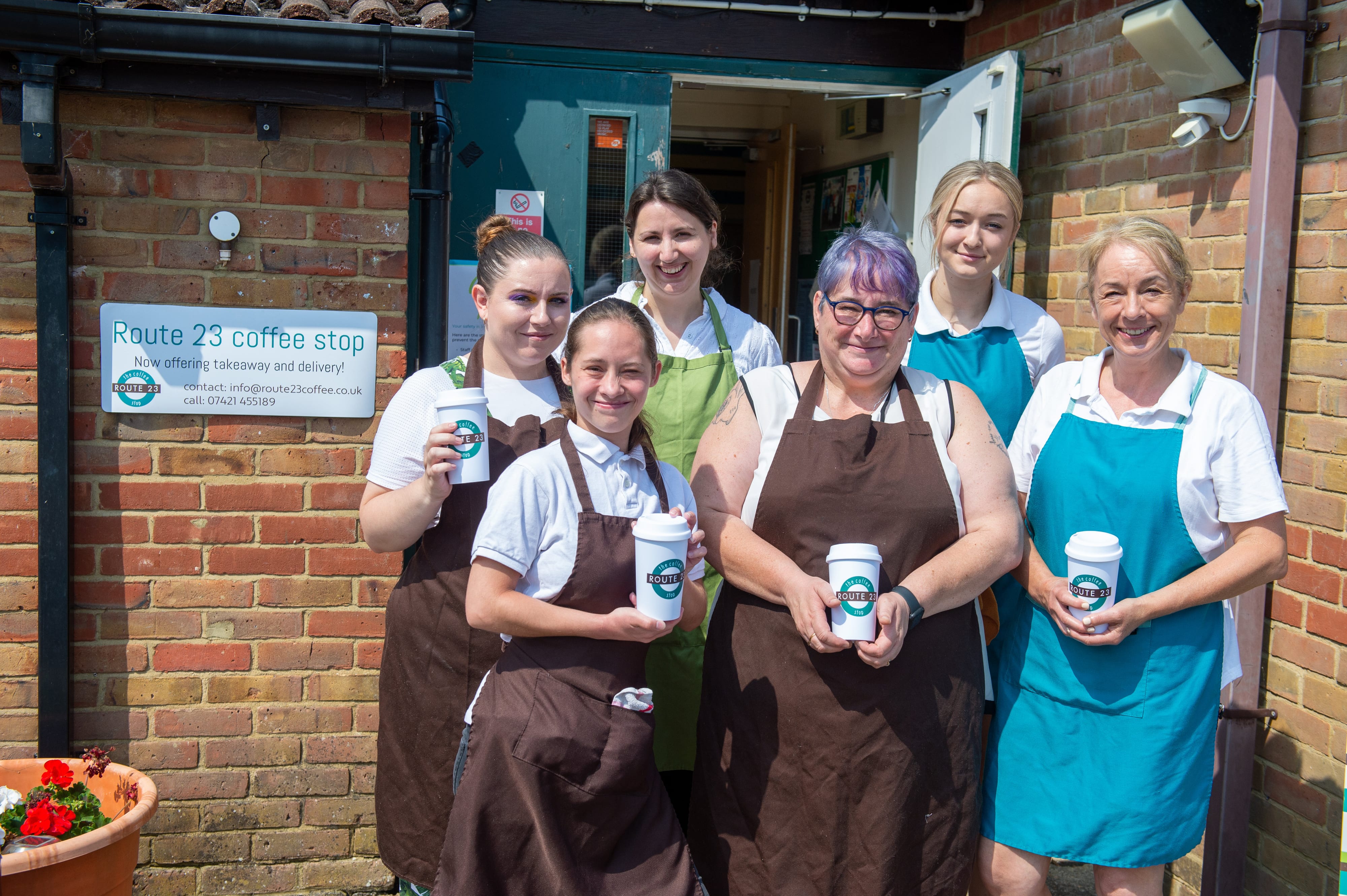 Group of volunteers holding coffee outside a cafe