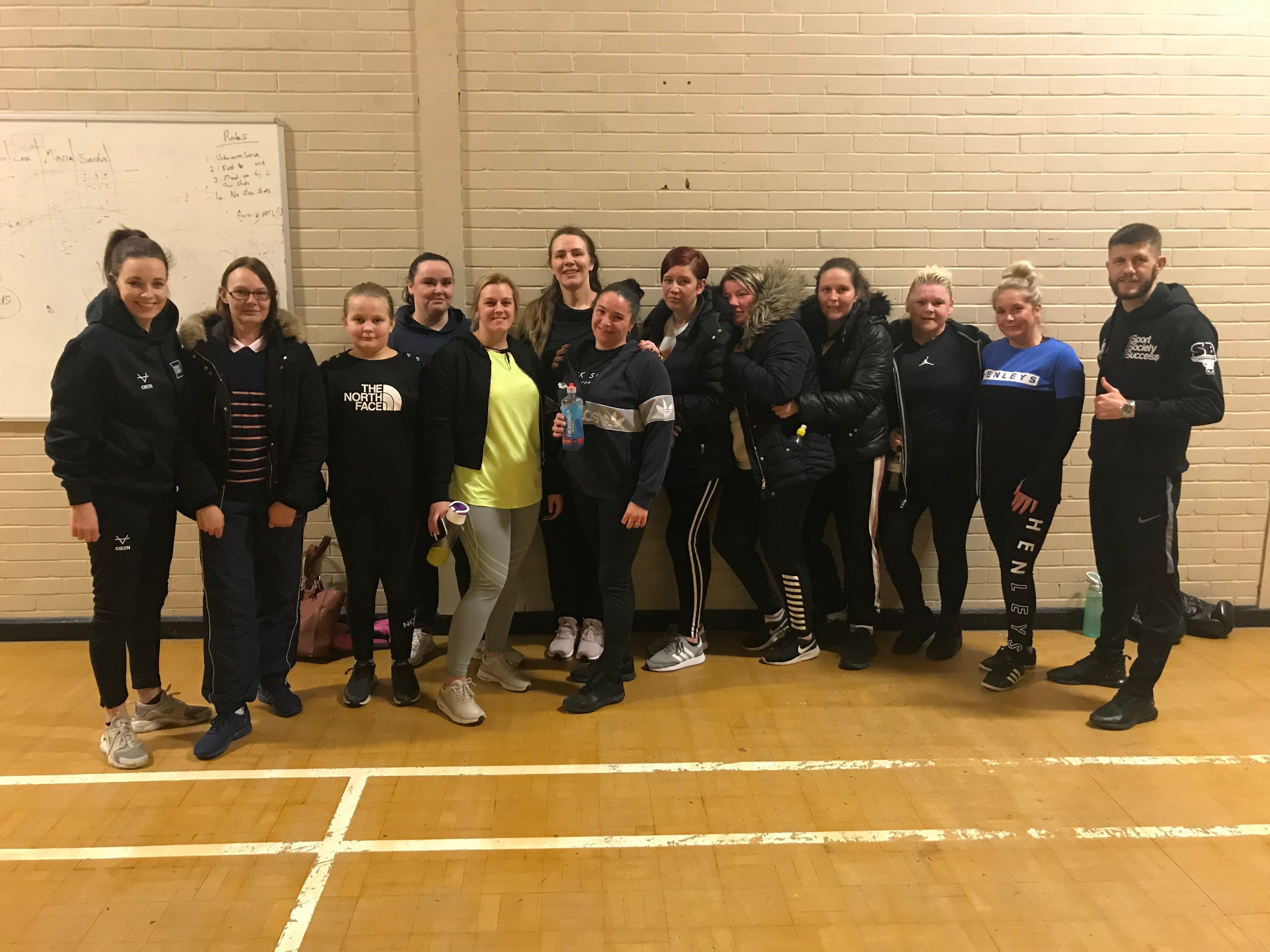 A group of parents and young people gather to take part in a boxing activity
